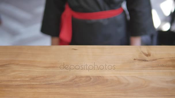Close-up - o garçom colocou o sushi a bordo na mesa no restaurante — Vídeo de Stock