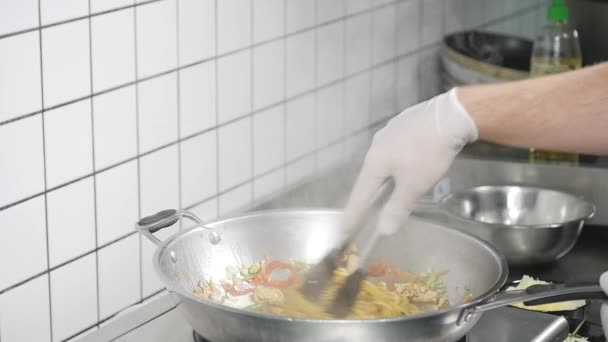 Aziatisch restaurant keuken, chef-kok koken voedsel, jongeman als professionele kok werken — Stockvideo