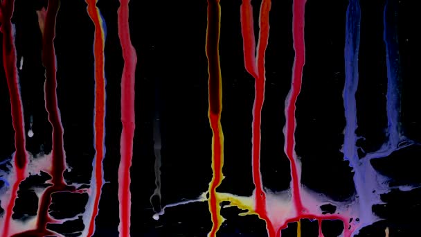 Des gouttelettes d'encre colorées glissent sur le verre. fond noir . — Video