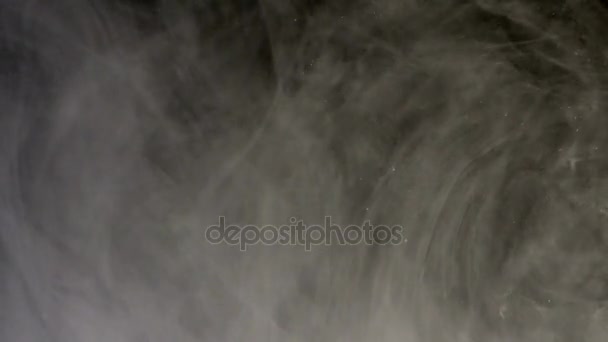 Weiße Tinte tropft in Wasser auf dunklem Hintergrund. Abstraktion — Stockvideo