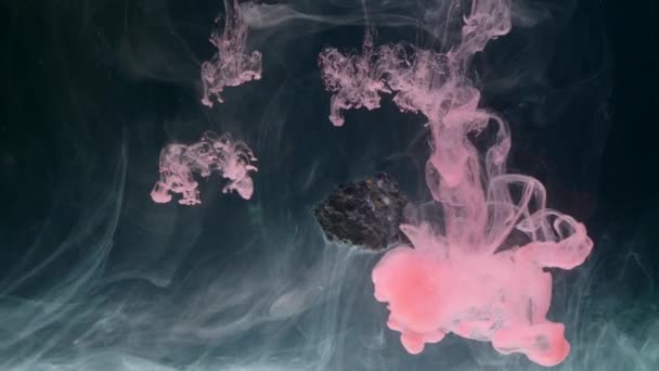 Tinta abstrak mengalir dalam air dengan batu — Stok Video