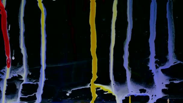 Des gouttelettes d'encre colorées glissent sur le verre. fond noir . — Video