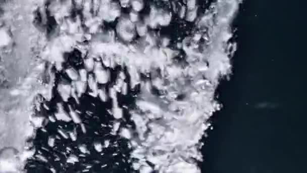 Verter agua y hacer salpicaduras sobre fondo negro — Vídeo de stock