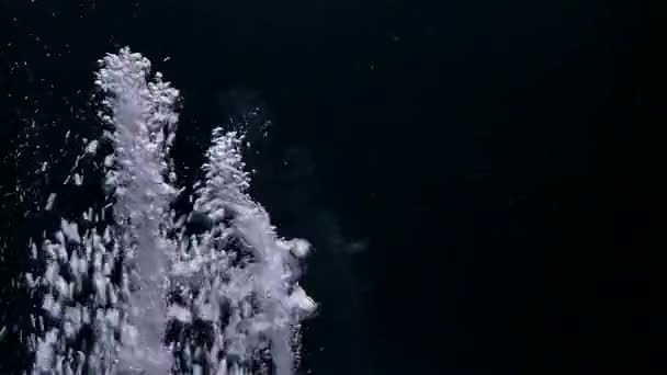 Despejar água e fazer salpicos no fundo preto — Vídeo de Stock