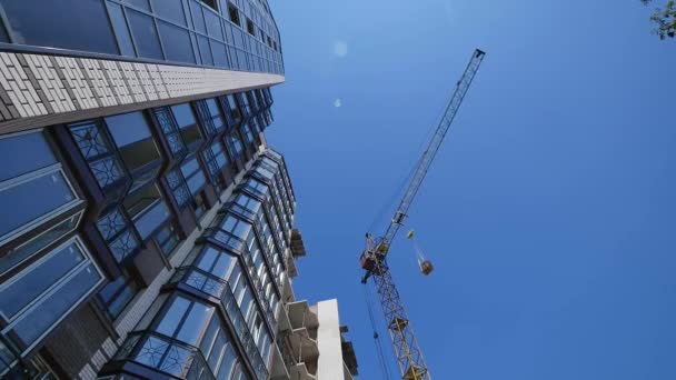 Site de construction avec grues sur fond de ciel — Video