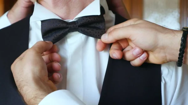 Belle matinée de marié dans la chambre d'hôtel. Le marié porte une cravate papillon — Photo