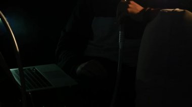 Genç adam sigara nargile ve yakın çekim sağlar karanlık bir odada duman halkaları