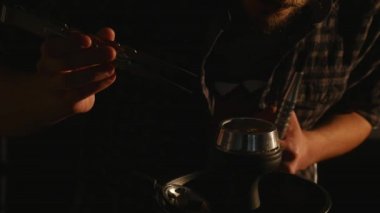 Genç adam sigara nargile ve yakın çekim sağlar karanlık bir odada duman halkaları