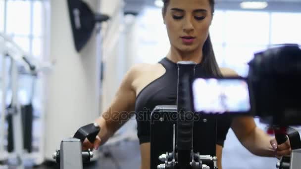 Femme entraîne les bras et les épaules sur simulateur dans la salle de gym — Video