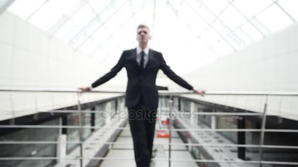 El empresario se queda en el balcón del centro de negocios — Vídeos de Stock