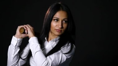 Vahşice kameraya bakarak, yarasa siyah arka plan üzerinde tutan genç güzel kız. ağır çekim