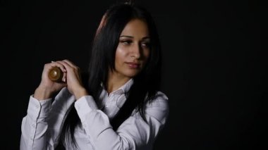 Vahşice kameraya bakarak, yarasa siyah arka plan üzerinde tutan genç güzel kız. ağır çekim