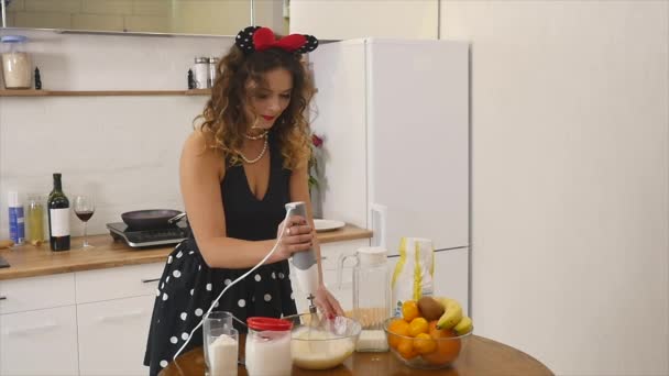 Jonge vrouw maakt deeg mengen ingrediënten in de kom met behulp van garde in de keuken. Zelfgemaakt voedsel. Langzame schot — Stockvideo