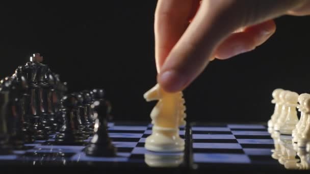 Jogo de tabuleiros de xadrez e peças de xadrez sobre fundo preto — Vídeo de Stock