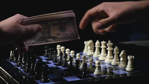 Tabuleiros de xadrez e peças de xadrez jogo sobre fundo preto. jogo por dinheiro — Vídeo de Stock