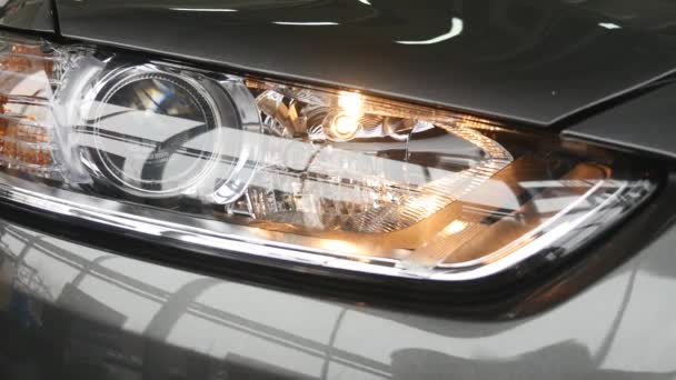 Closeup on a headlight of a dark gray car — Stock Video