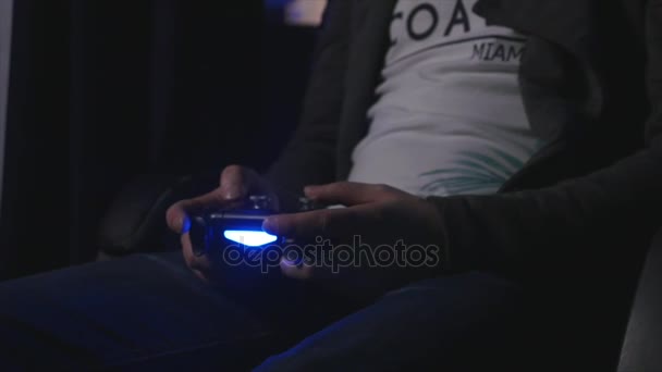 Man spelar med en videogame controller i händerna — Stockvideo