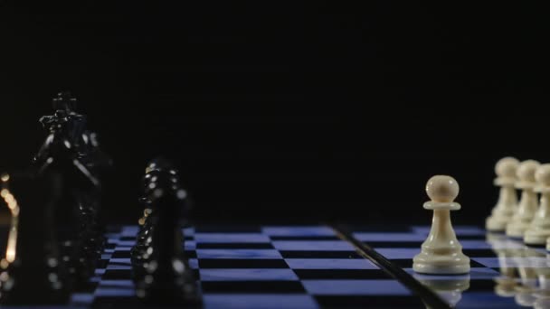 Шахматные доски и шахматные фигуры игры на черном фоне — стоковое видео