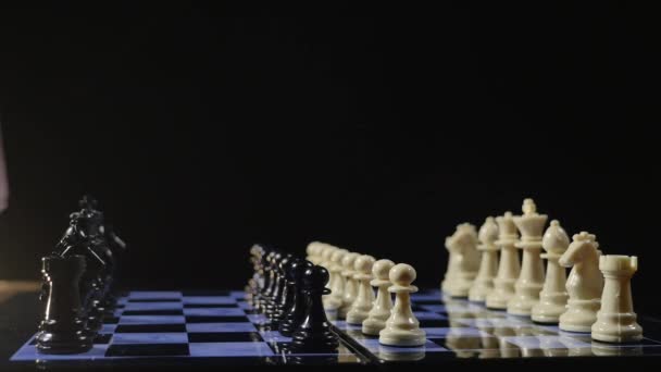 Tableros de ajedrez y piezas de ajedrez juego sobre fondo negro — Vídeo de stock