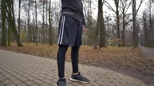 Hombre atlético joven haciendo calentamiento antes del ejercicio y trotar — Vídeos de Stock