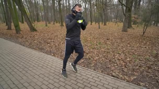 Hombre atlético joven haciendo calentamiento antes del ejercicio y trotar — Vídeos de Stock