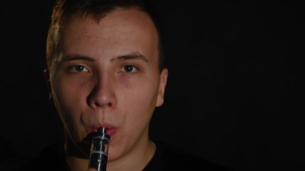 Az ember a dohányzás elektronikus cigaretta vapor-fekete háttér — Stock videók