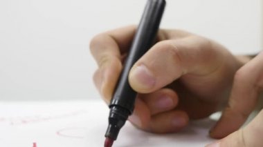 Kağıda yazı işaretçisiyle el closeup mans