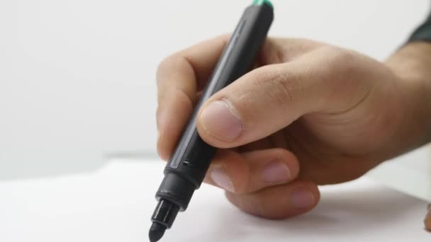 Close-up van mans hand schrijven op papier met marker — Stockvideo