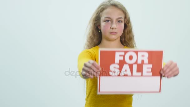 A menina mostra um sinal "para VENDA " — Vídeo de Stock