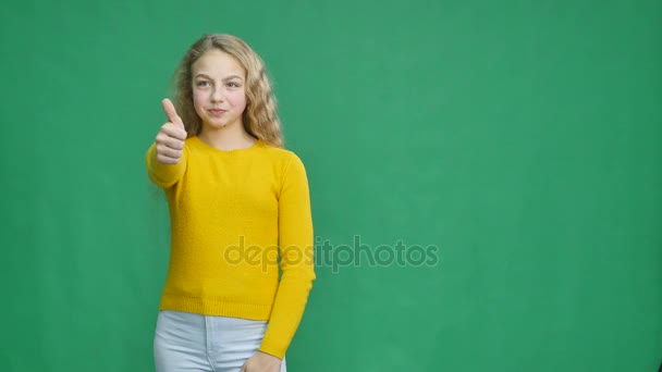 Girl showing thumbs up isolated on a green background — Stock Video