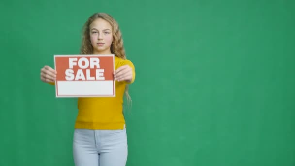 Dívka ukazuje znamení "na prodej" — Stock video