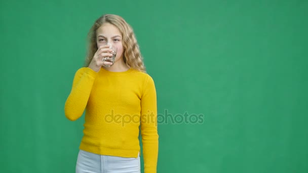 Portret van meisje drinkwater, geïsoleerd in het groen — Stockvideo