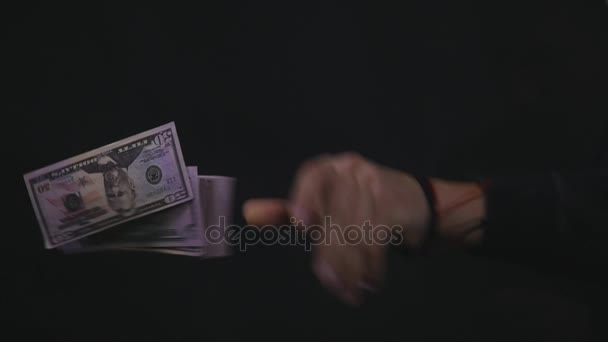 若い男が暗い背景上のお金を投げる — ストック動画