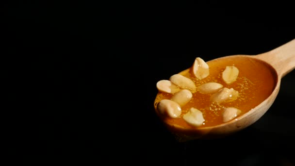 Miel y nueces en cuchara de madera de cerca — Vídeos de Stock
