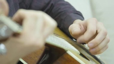 Yakın çekim, bir adamın elinde bir gitar çalmak
