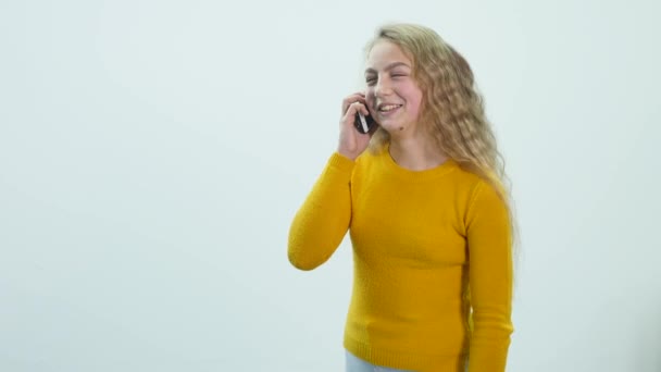 Linda, menina adolescente está falando no telefone celular e sorrindo — Vídeo de Stock