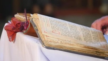 Kutsal İncil okuma. Eller Ortodoks rahip sayfayı kapatır