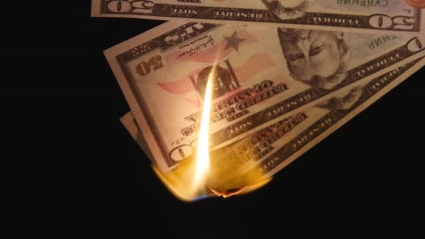 Hořící dolarů zblízka nad černým pozadím — Stock video