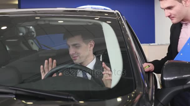 Acheteur ayant une conversation avec le vendeur de voiture pendant l'inspection de la voiture — Video