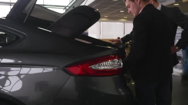 Muž se dívá na kufru v autodům — Stock video