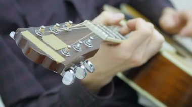 Yakın çekim, bir adamın elinde bir gitar çalmak