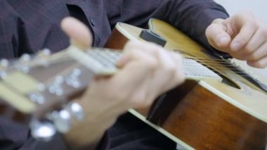 Yakın çekim, bir adamın elinde bir gitar çalmak
