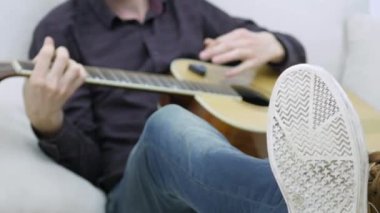 Yakın çekim, bir adamın elinde bir gitar çalmak