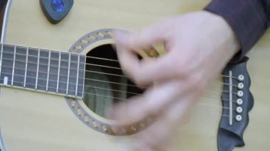 Yakın çekim, bir adamın elinde bir gitar çalmak