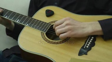Yakın çekim, bir adamın elinde bir gitar çalmak