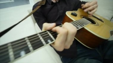 Yakın çekim, bir adamın elinde bir gitar çalmak