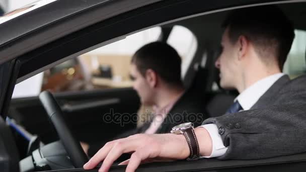 Покупатель разговаривает с продавцом автомобилей во время осмотра автомобиля — стоковое видео