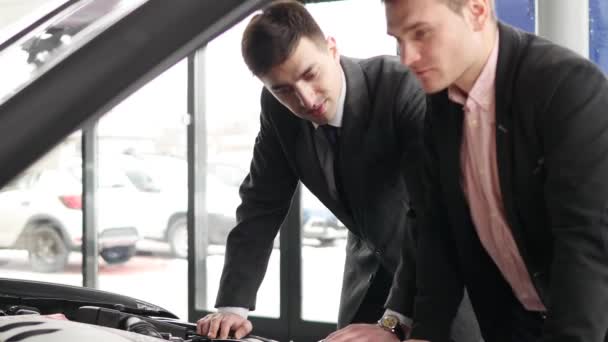 年轻男子看着在经销商的发动机车厢 — 图库视频影像