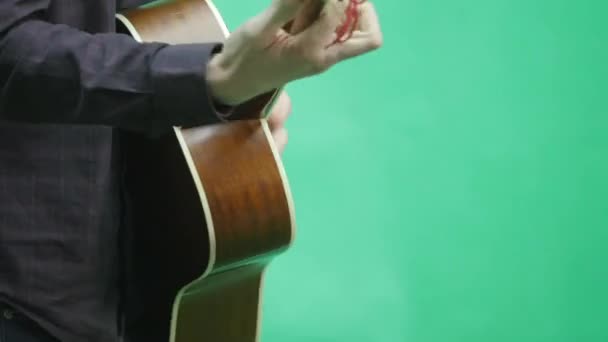 Молодой человек играет на гитаре на зеленом экране — стоковое видео