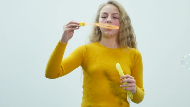 Teenager-Mädchen lässt Seifenblasen aus. weißer Hintergrund — Stockvideo